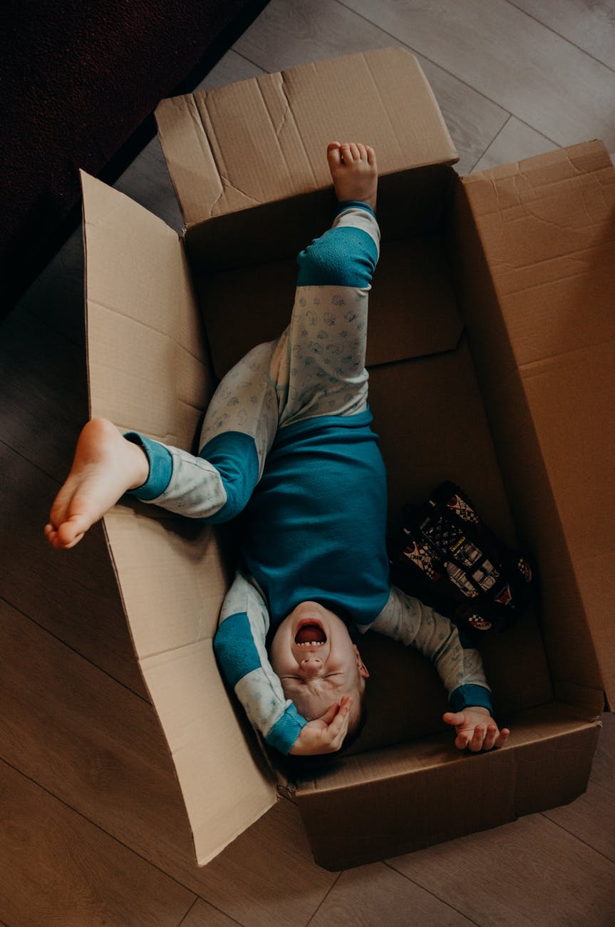 little boy crying inside a box